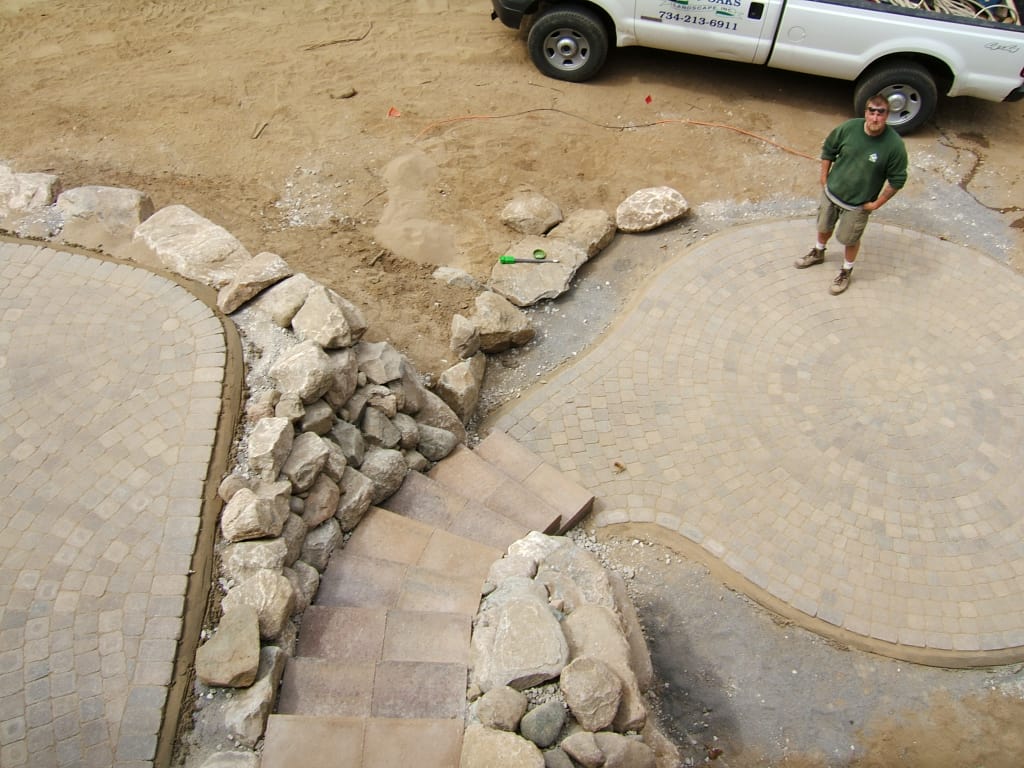 Twin Oaks employee standing on finished patio paver project