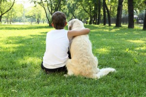 boy hugging his dog outside