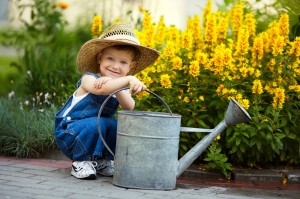 young boy with large watering can