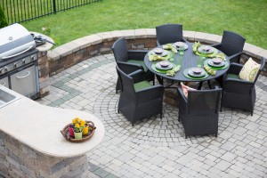 Outdoor kitchen and patio with a retaining wall.