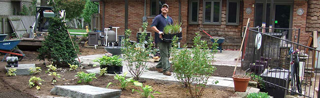 Twin Oaks worker carrying potted plants