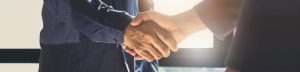 Close up of two men shaking hands.