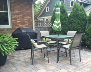 Brick paver patio with outdoor furniture and plants.