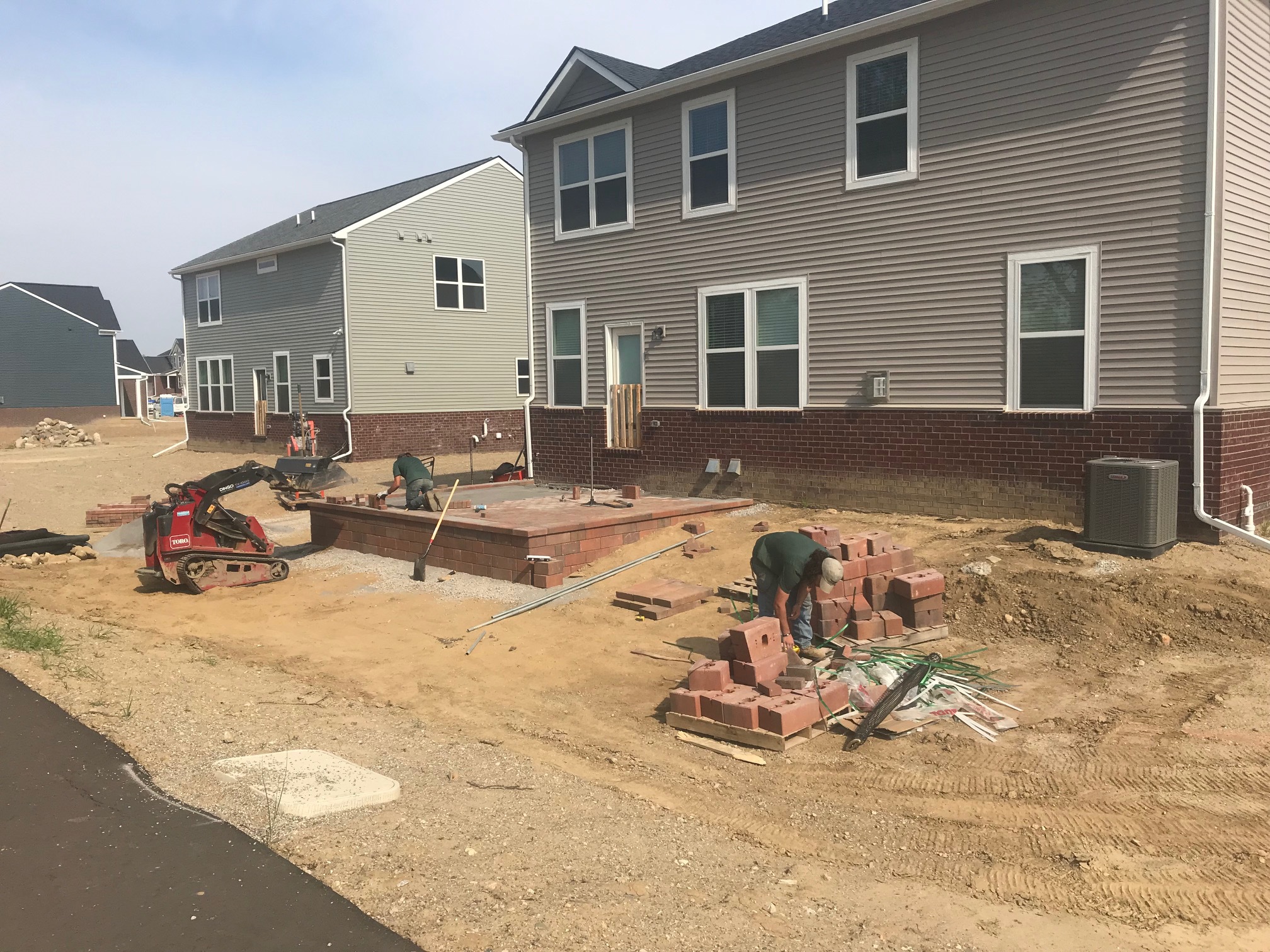 Newly constructed house with landscape being installed in the backyard.