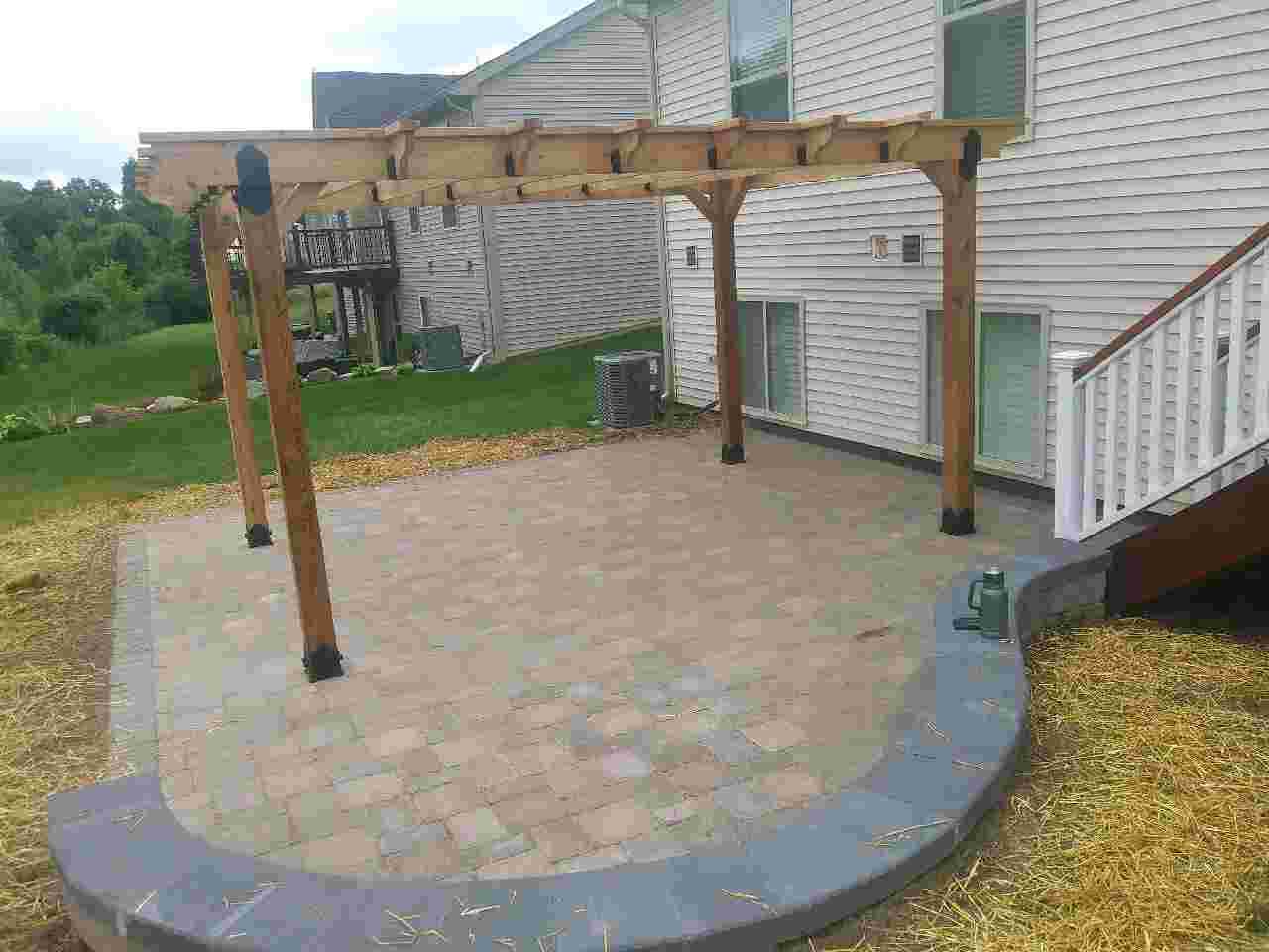 Paver patio, new pergola, and landscaping created by a professional landscape service.
