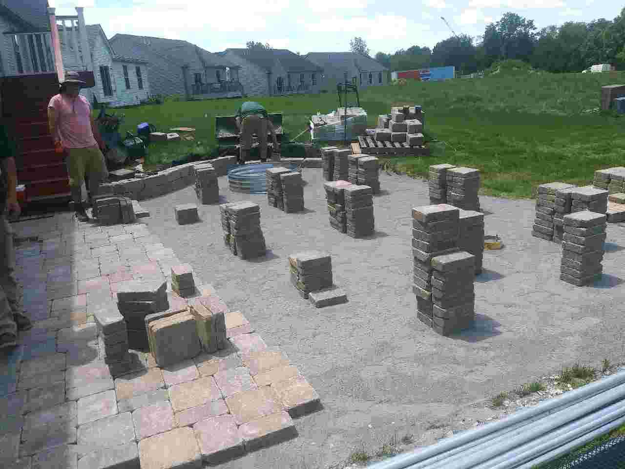 Installing paver patio and landscape in a backyard.
