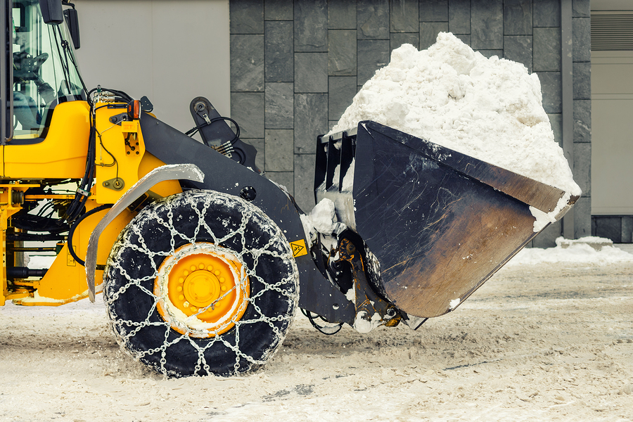 Commercial snow removal service cleaning up after a snow storm.