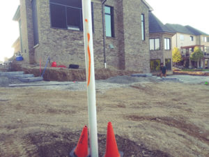 white pole with a house in the background. in progress shot of the paver driveway and landscape project