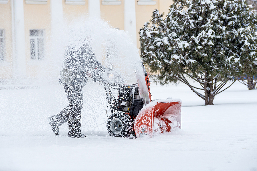 Snow-removal work with a snow blower. Man Removing Snow. heavy precipitation and snow piles