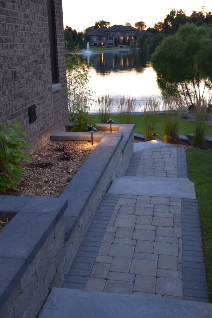 Paver walkway lined with lights at dusk.