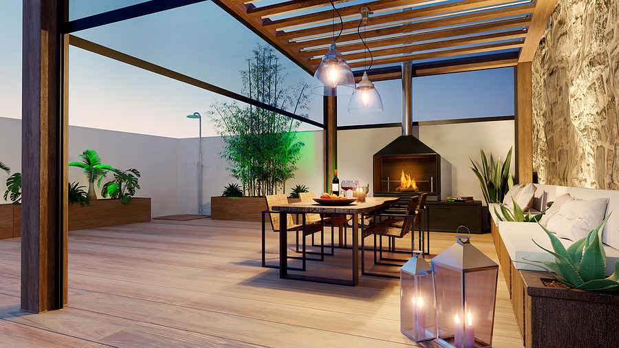 3D illustration of urban terrace at twilight with fire place and wooden table. Teak wood bioclimatic pergola and flooring.