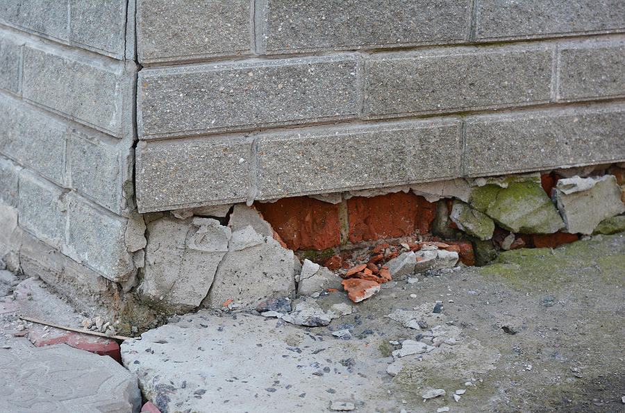 Foundation house wall damage from wetness. Foundation walls without waterproofing. Cracked foundation wall corner.