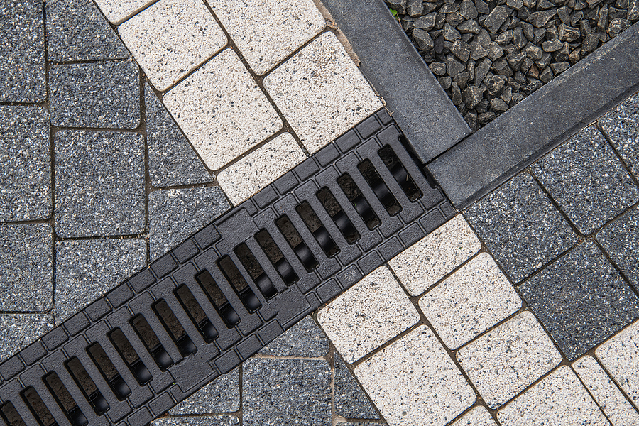 Concrete Bricks in Two Different Colors and Residential Driveway Water Drain Close Up. 