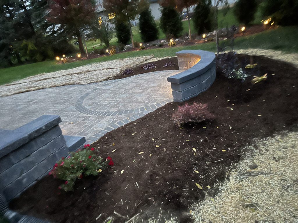 Landscaped paver patio with curved wall