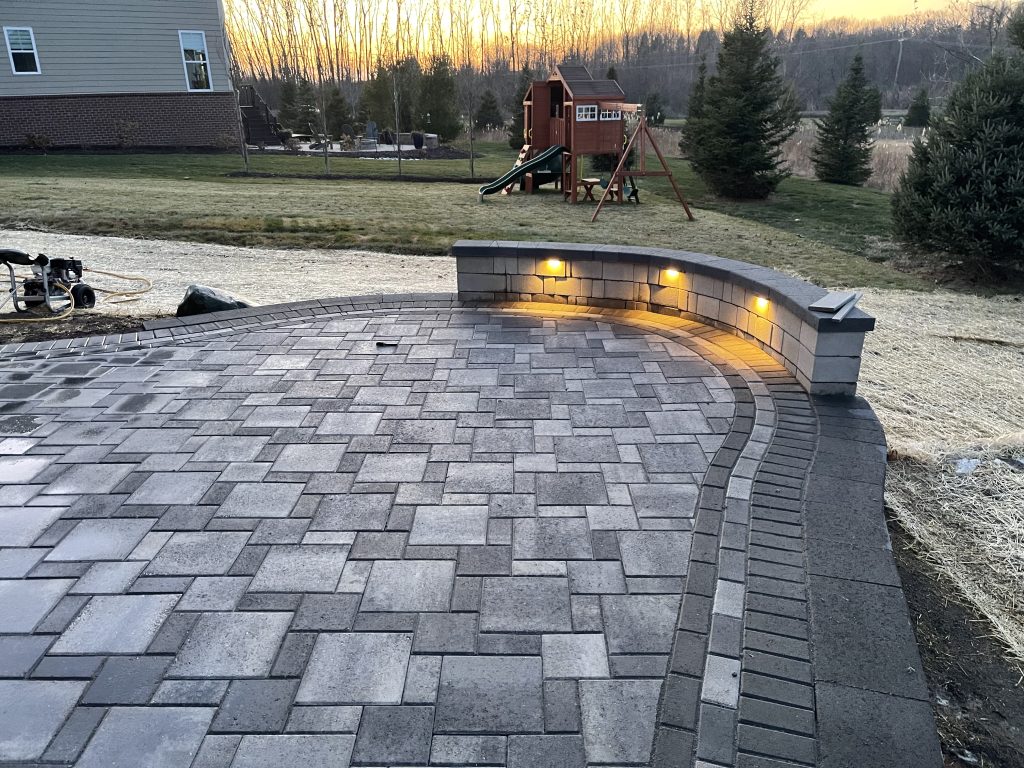 Patio with seating. Landscape lighting is installed in the bench seat